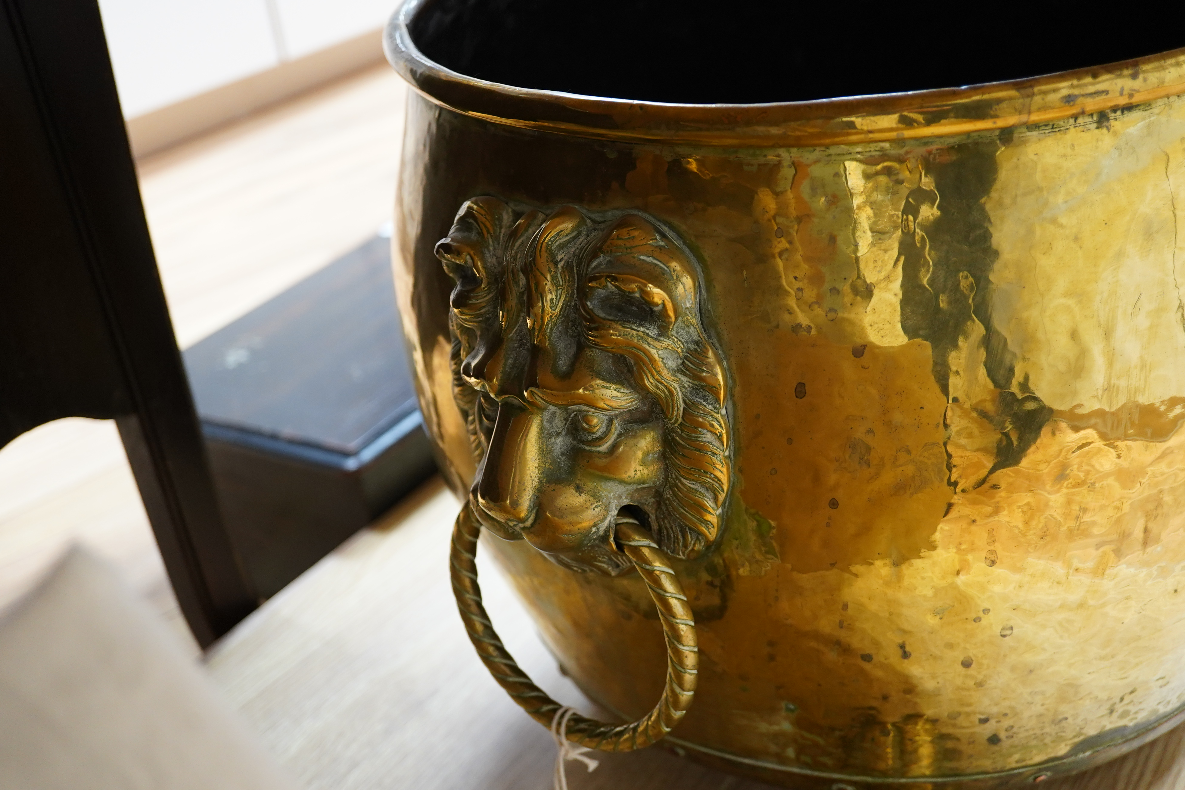 A large Victorian brass log bucket with lions head handles and paw feet, 50cm in diameter. Condition - fair to good